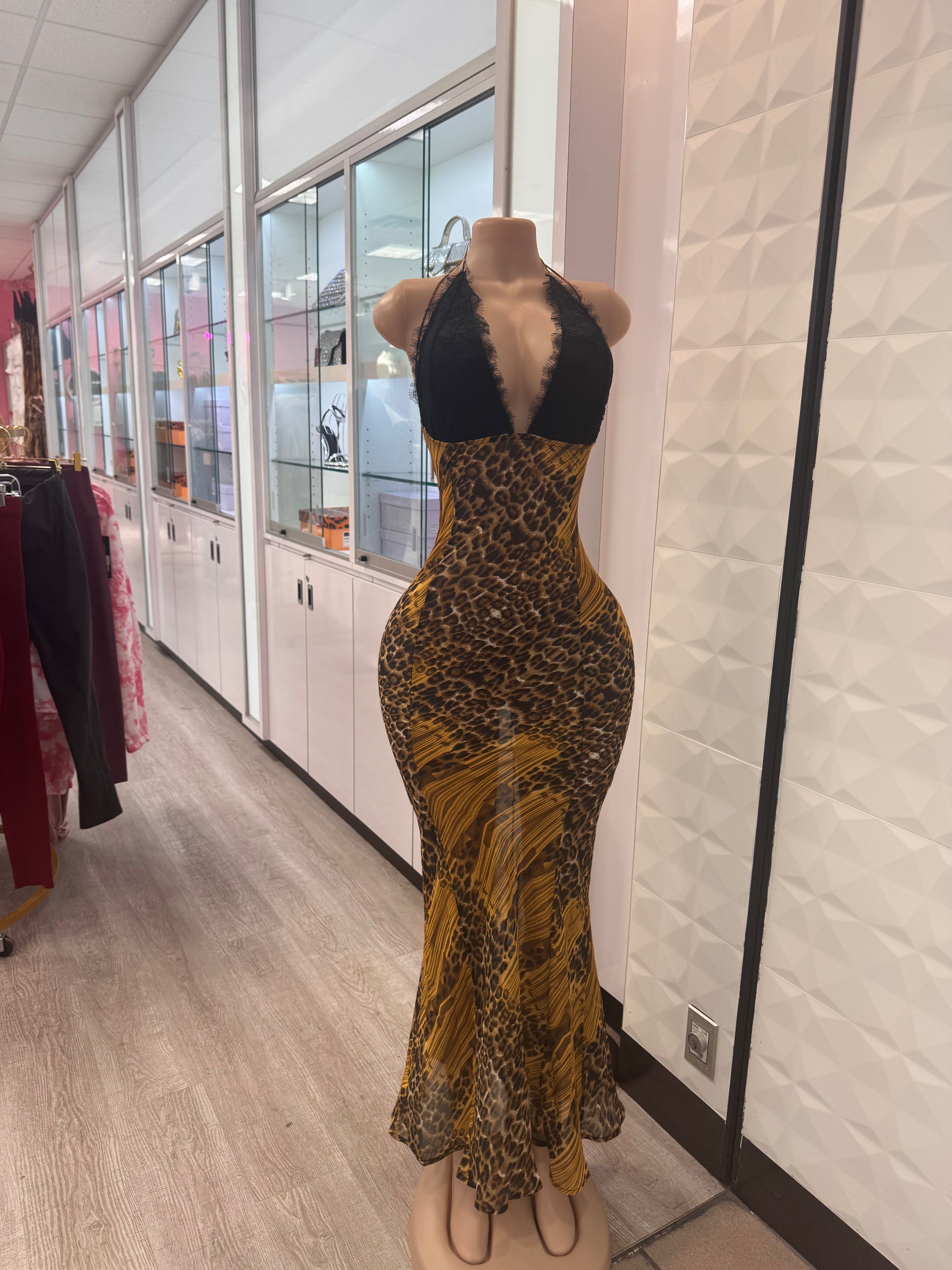 Mannequin displaying a stunning leopard print maxi dress in a retail store, showcasing its vibrant colors and form-fitting design.