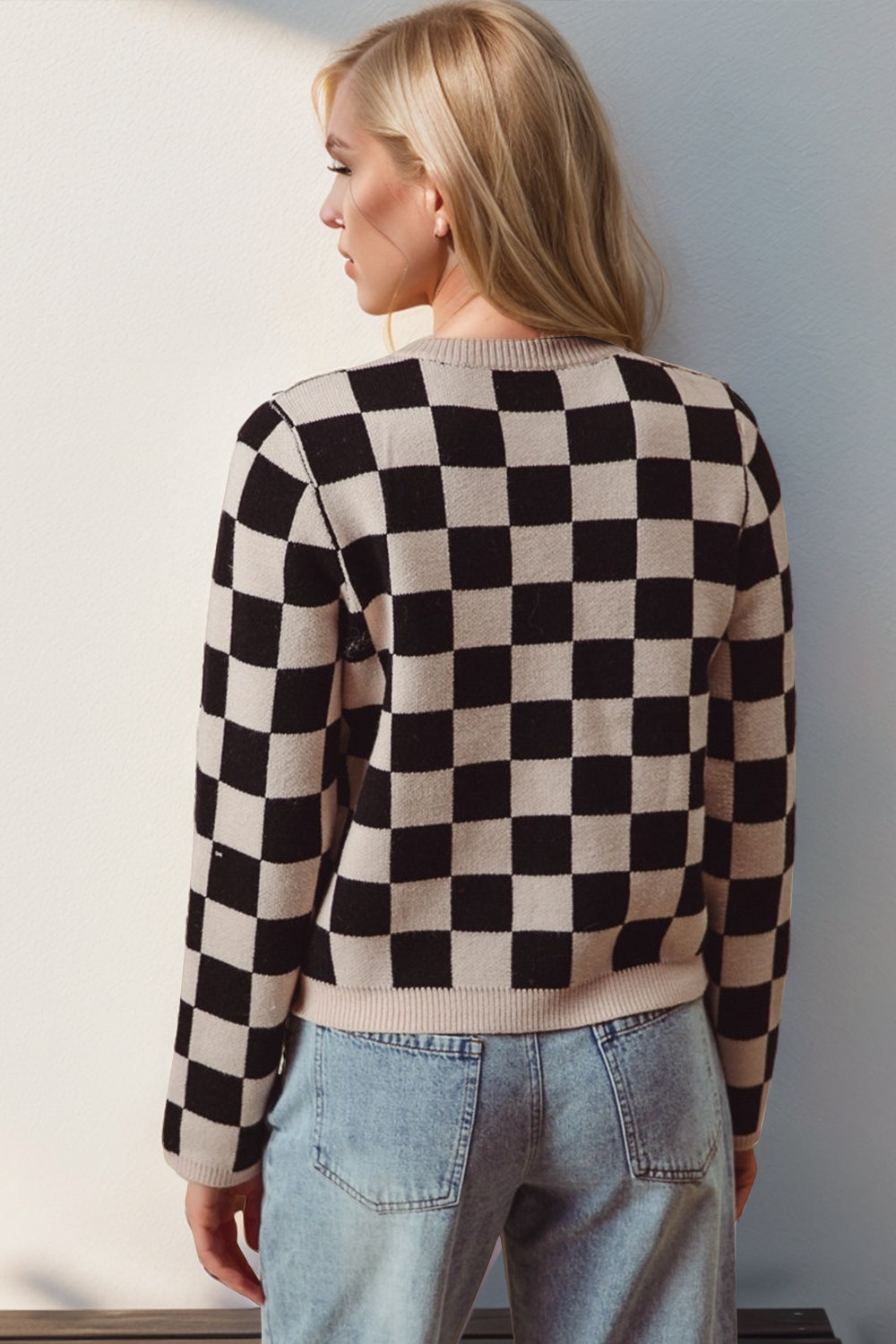 a woman wearing a black and white checkered sweater