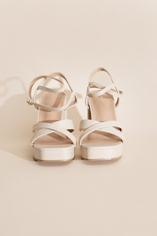 a pair of white high heeled sandals