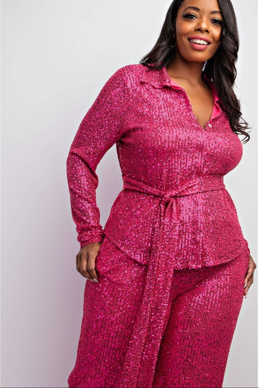 a woman in a pink jumpsuit posing for a picture