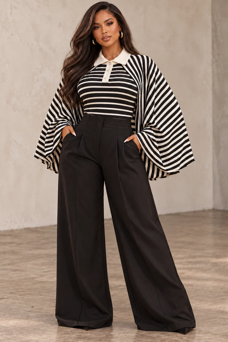 Model wearing the Bellamy black and ivory striped kimono-sleeve collared top with dramatic wide sleeves and a contrast polo collar, styled with black wide-leg trousers at Blaire Shops.