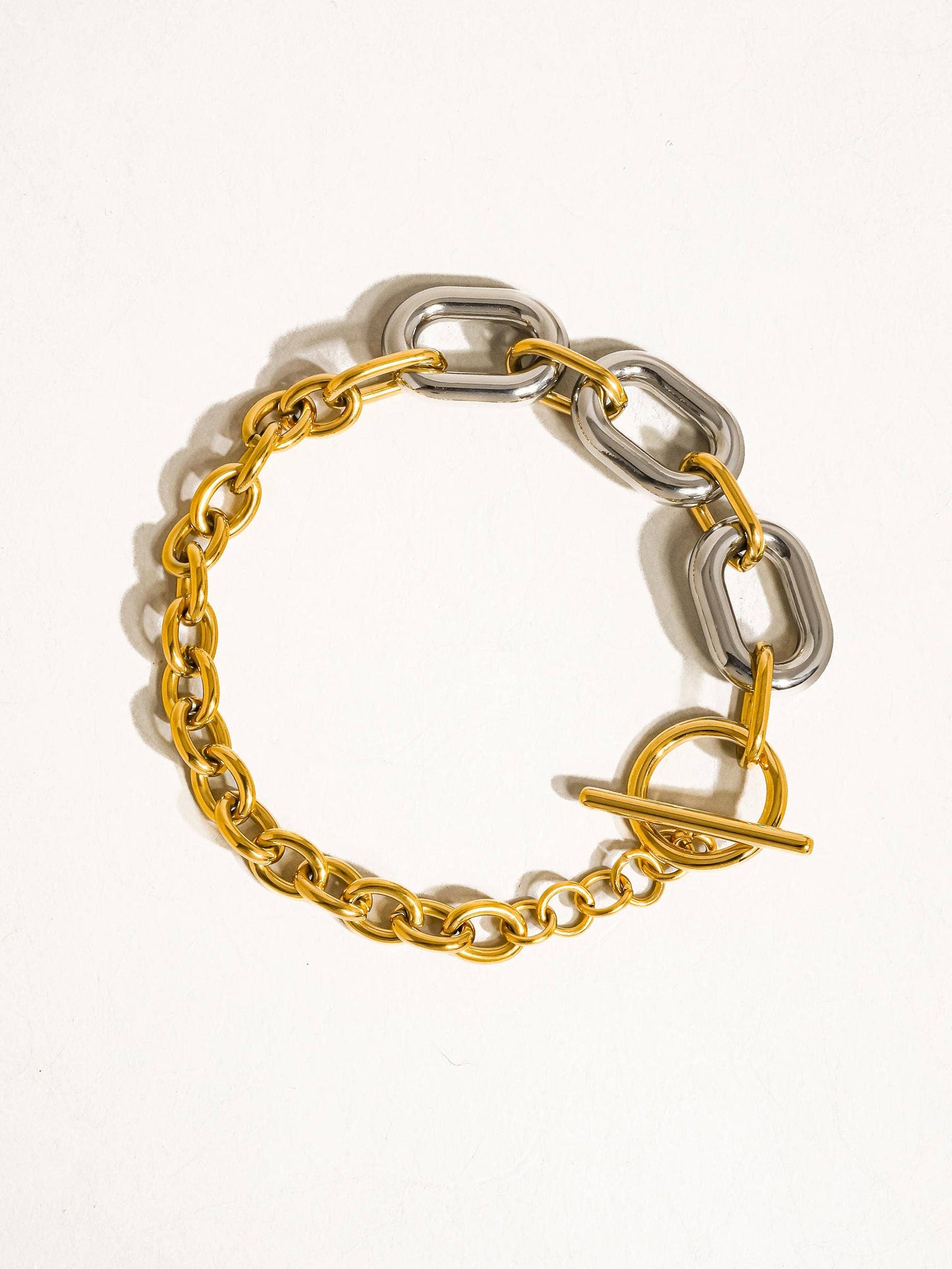 a gold and silver bracelet with a heart charm