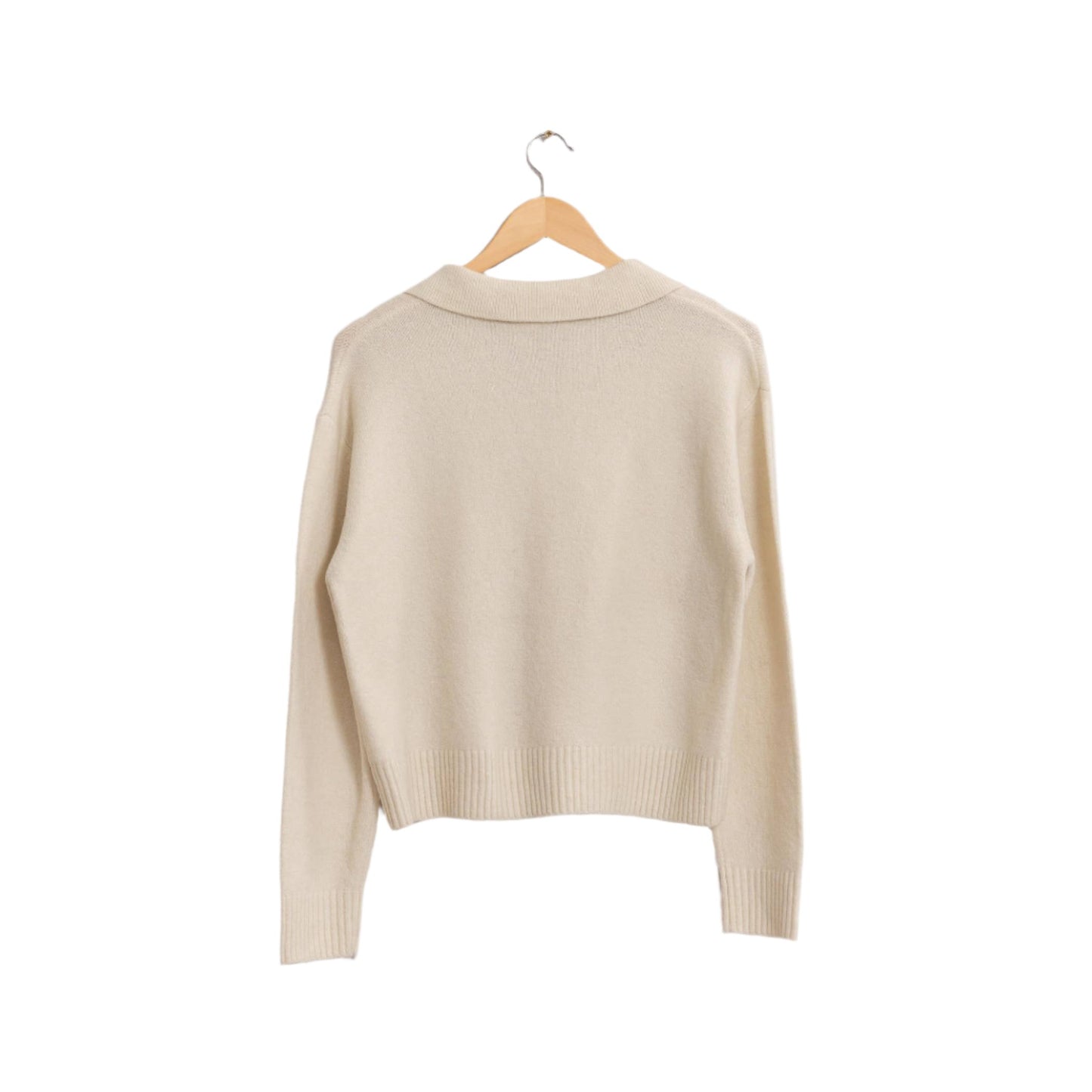 a white sweater hanging on a hanger