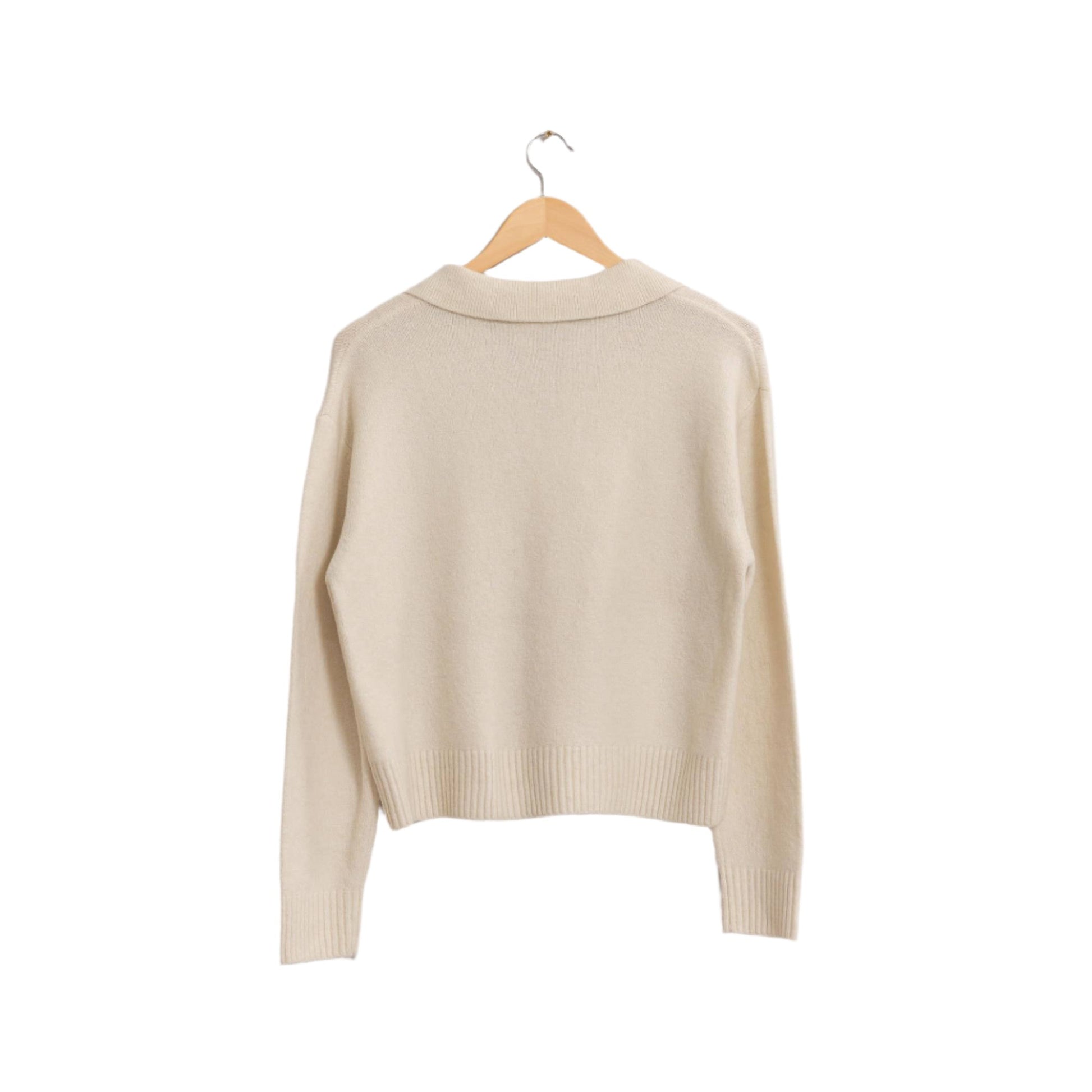 a white sweater hanging on a hanger