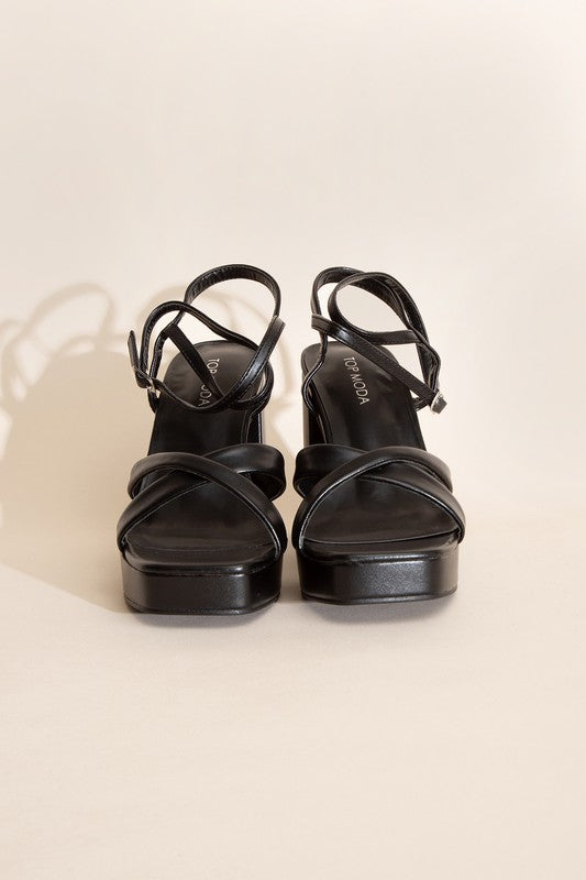 a pair of black high heeled shoes on a white background