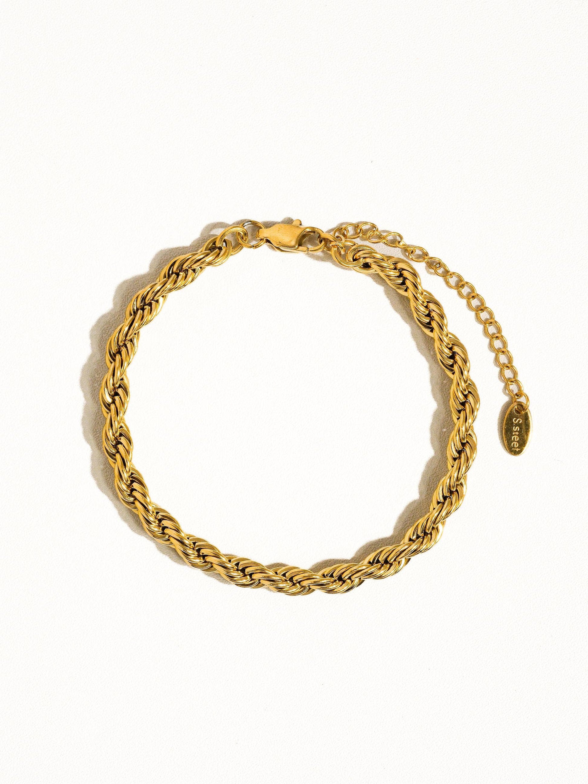 a gold bracelet with a coin on it