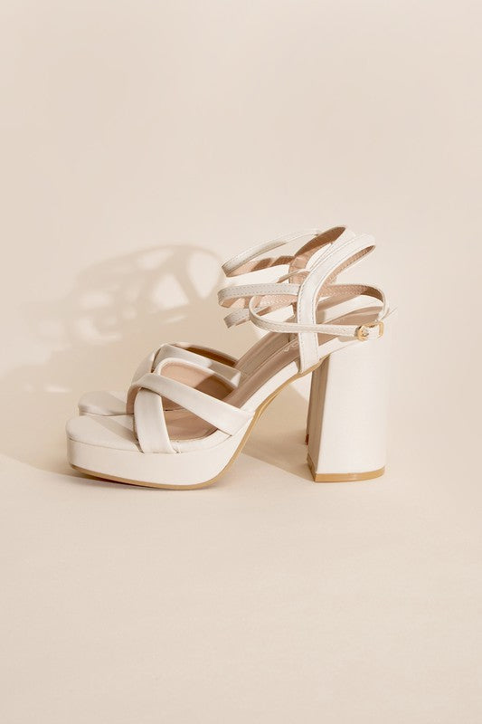 a pair of white high heeled sandals