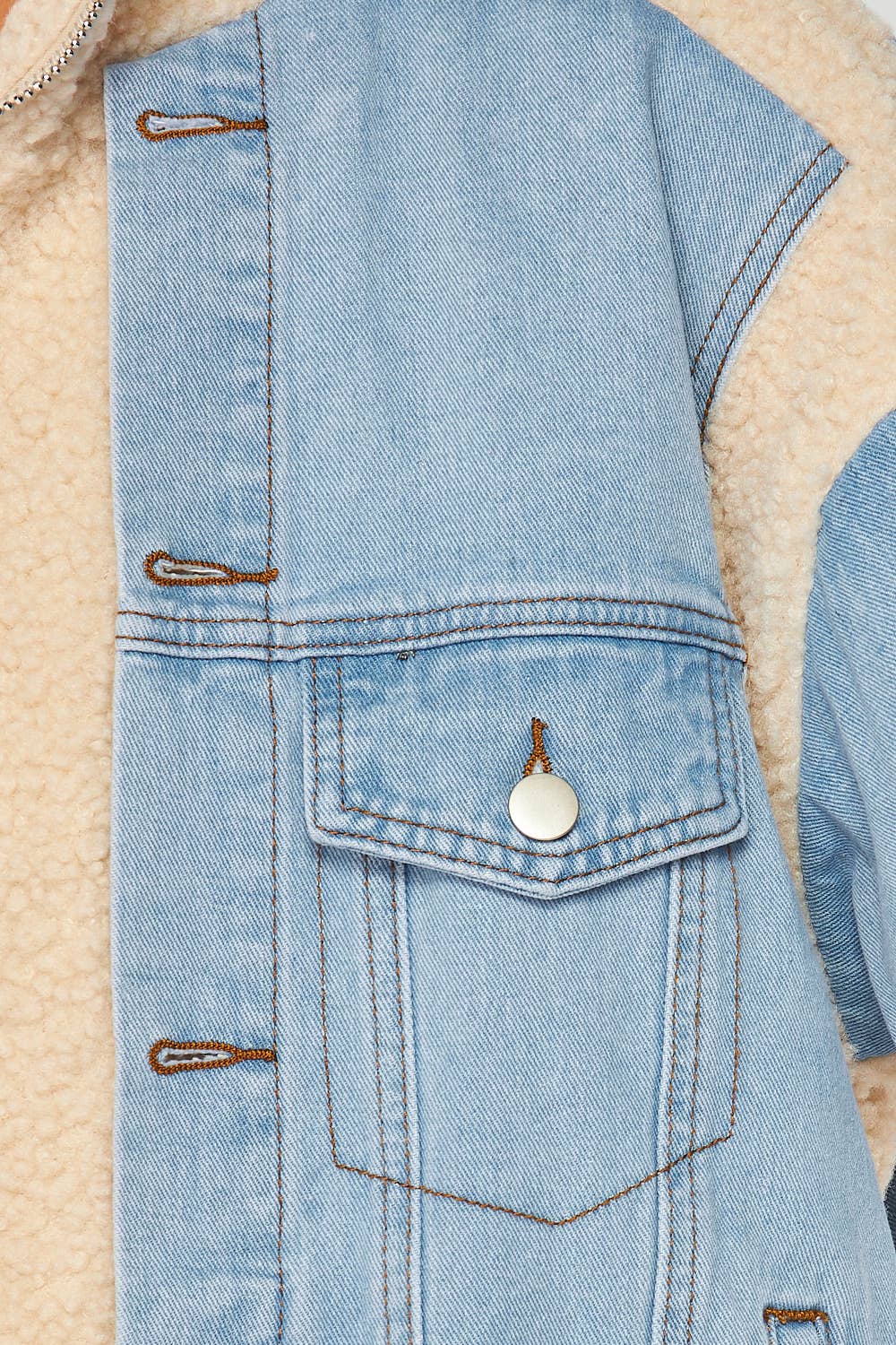 a blue jean jacket with a white button