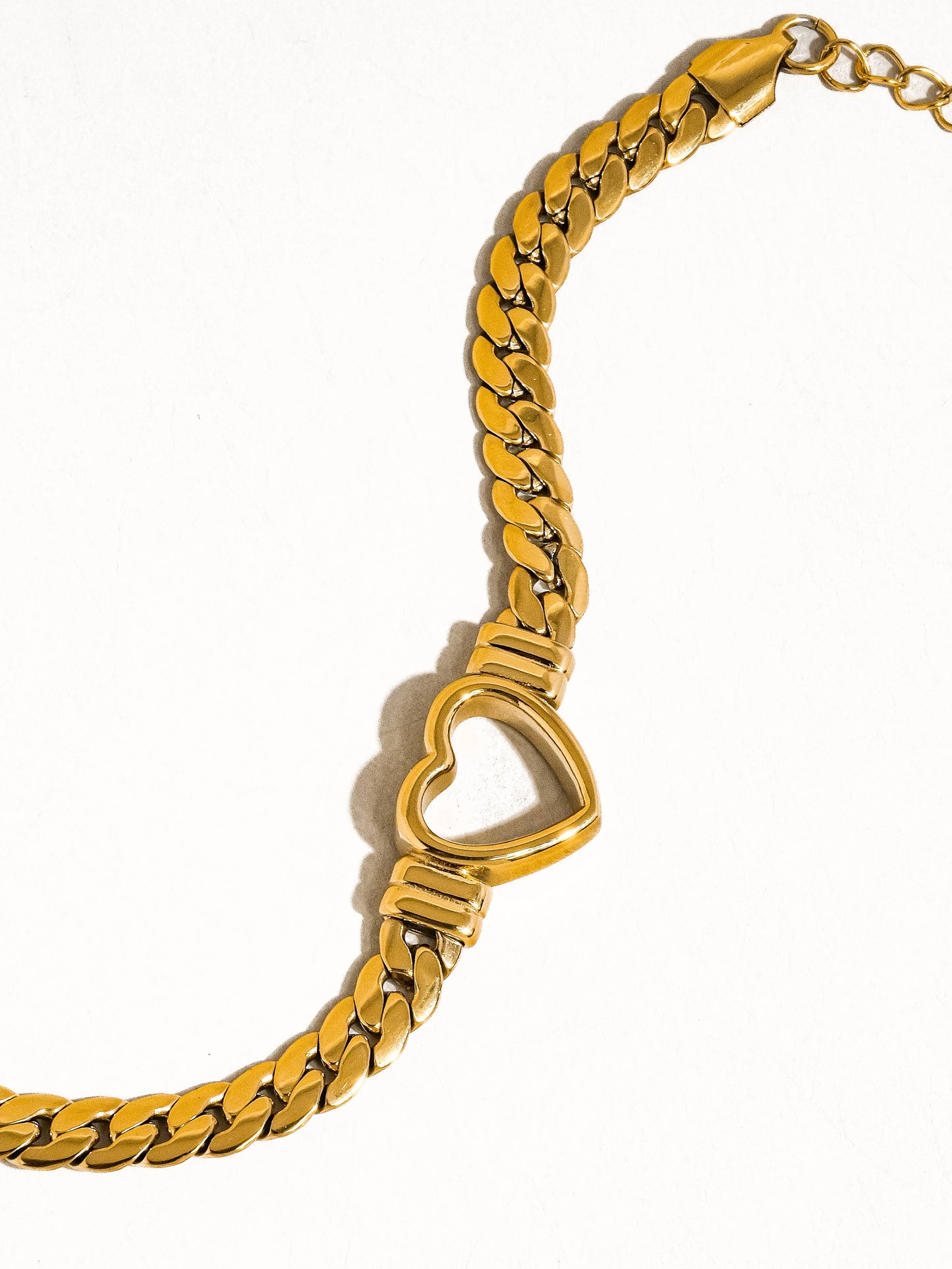 a gold bracelet with a heart shaped clasp