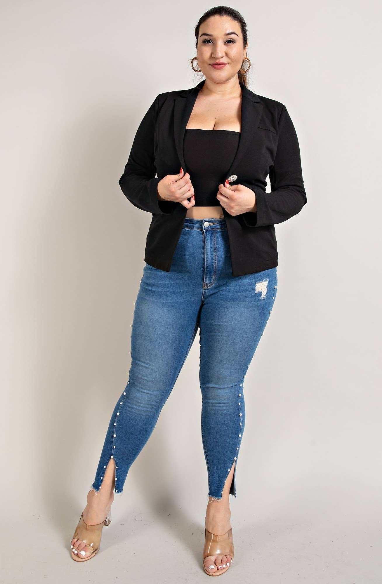 a woman in a black top and jeans posing for a picture