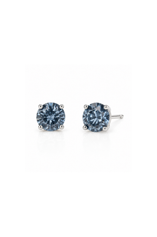 A pair of round-cut stud earrings featuring light blue gemstones in a four-prong setting with silver-toned posts, shown on a plain white background.