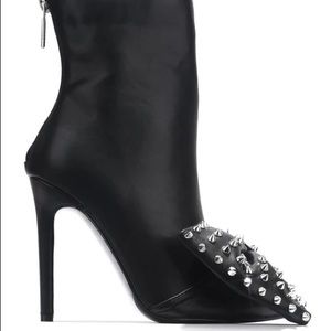 a pair of black high heeled boots with spikes